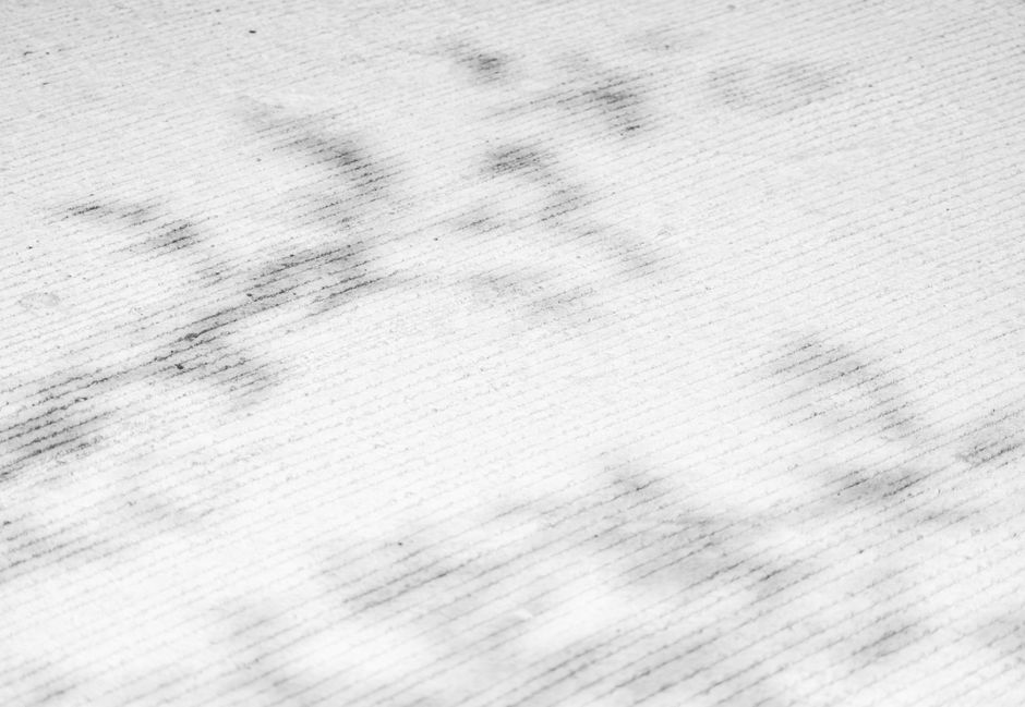Close-up image of a white paper surface showing visible dark smudges and stains, with a textured pattern of fine lines. The paper appears to have been marked or soiled, possibly from use or handling. This surface is likely being prepared for cleaning or stain removal processes, as part of a deep cleaning or surface sanitisation service. The background suggests a clean, well-lit environment, emphasizing the contrast between the soiled marks and the otherwise clean paper. The image is associated with the services offered by Carpet Cleaning Harringay, focusing on thorough surface cleaning and hygiene.